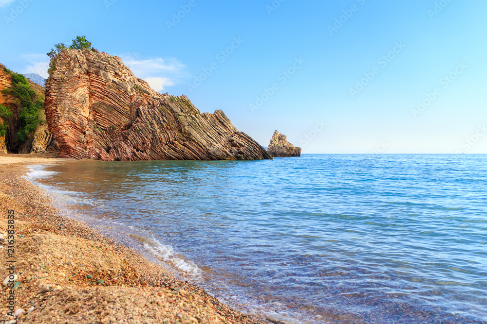 Adriatic sea coastline near Budva city in Montenegro, gorgeous seascape with big rock on the beach