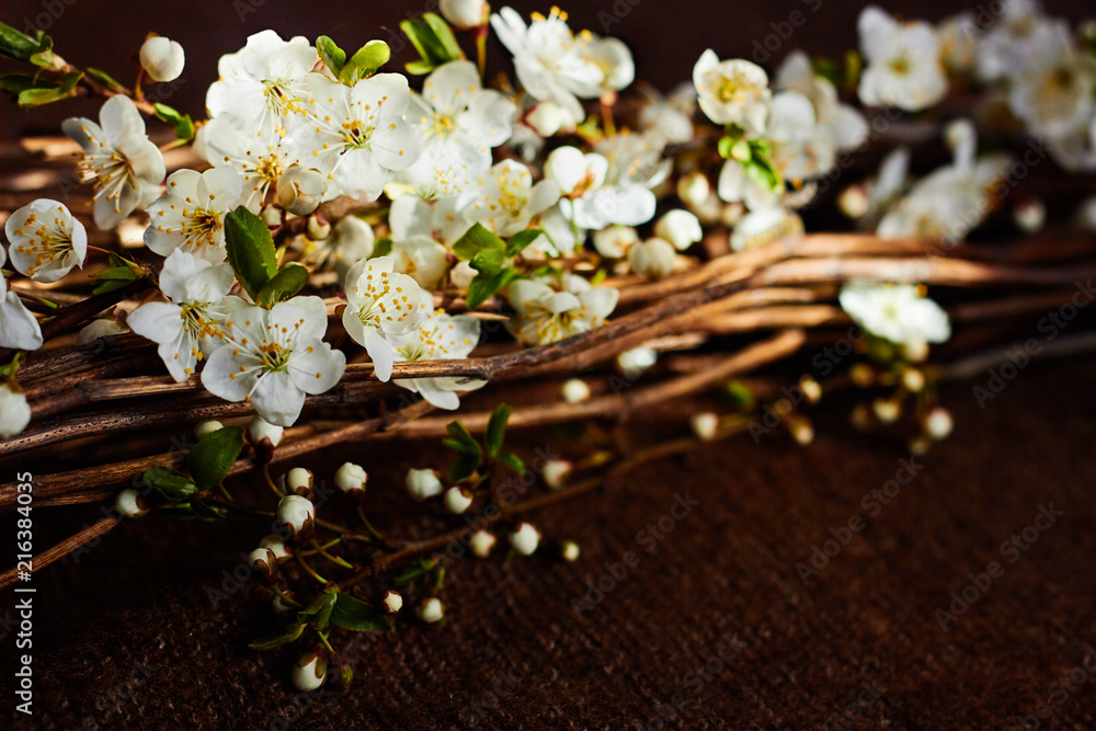 Spring blossoms mixed with dried stems laying on the woolen fabric diagonally, copy space left for text, close-up Spring blossoms mixed with dried stems laying on the woolen fabric diagonally, copy space left for text, close-up