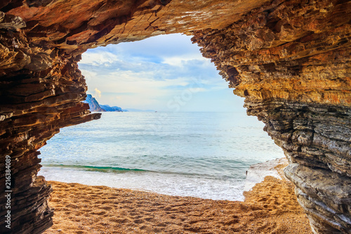 View from the cave in cliff to the blue Adriatic sea in Montenegro near Budva city, summer seascape