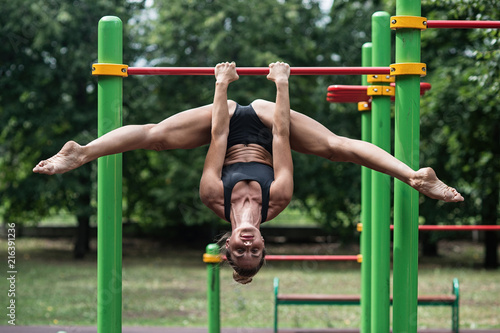 girl doing exercises on the horizontal bar. The woman is engaged in workout