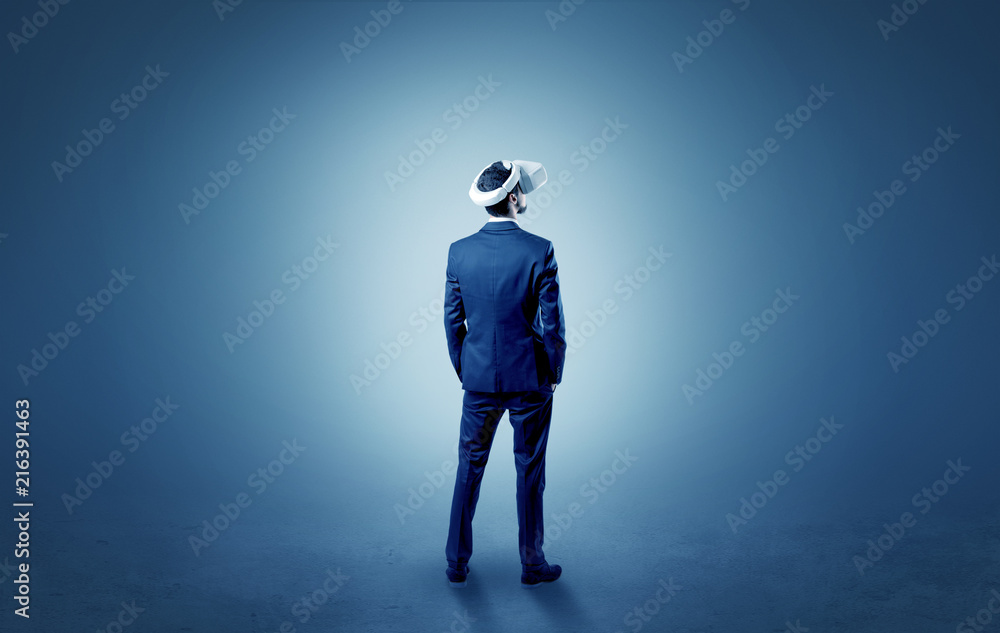 Fototapeta premium Businessman wearing vj glasse in an empty room with no wallpaper