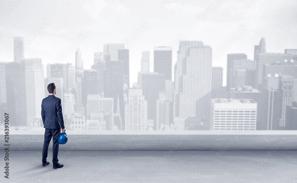 Businessman standing with his back on a roof with objects in his hand
Businessman standing with his back on a roof with objects in his hand