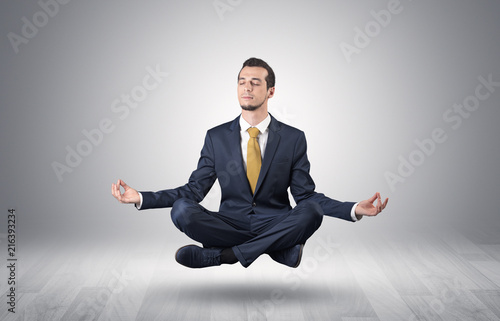 Businessman levitates and sitting in yoga position in an empty infinity space 