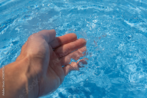 Abkühlung im heissen Sommer - Hand im Wasser