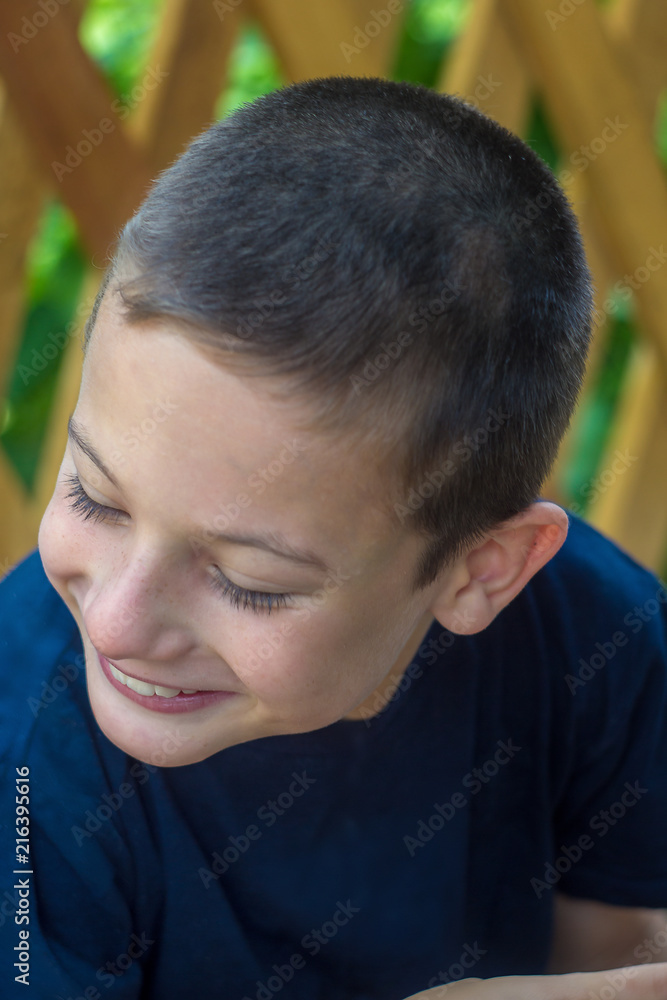 Obraz premium A child sick with infantile cerebral palsy outdoors in the village smiles and looks down.