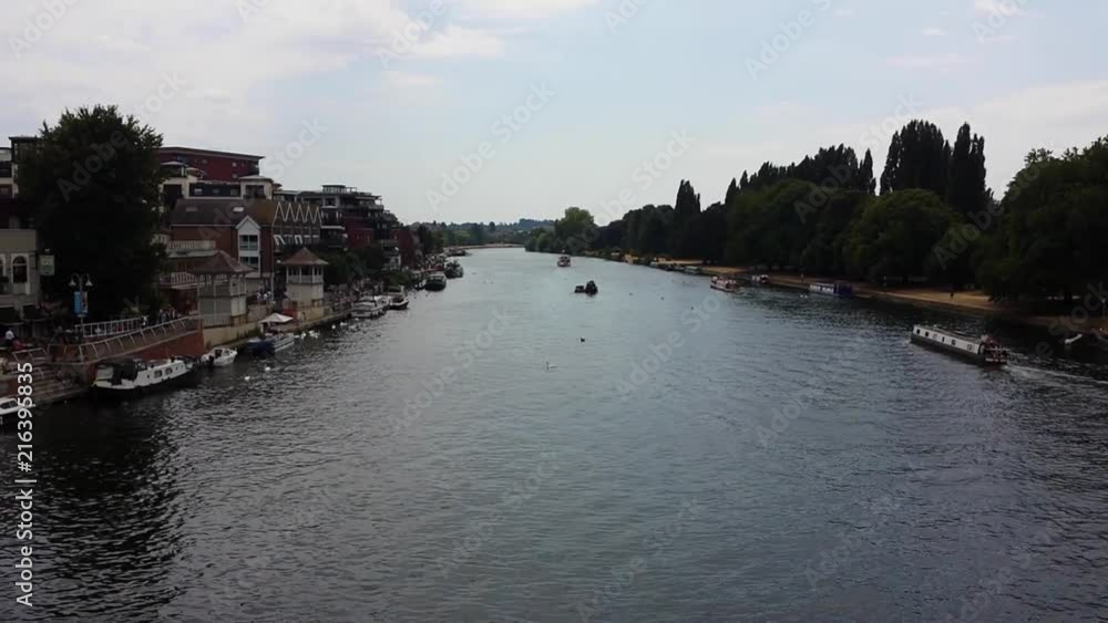 The River Thames at Kingston-upon-Thames, Surrey, England showing the riverbank and moored boats.