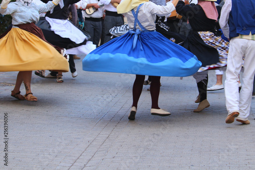 Swinging skirts of local dancers in traditional Canarian dresses at a public festival, in motion blur