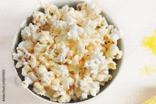 Popcorn in a round bowl. White background. Close-up. View from above. Macro photography.