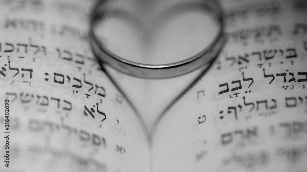 Close up of the Hebrew Jewish bible with a weeding ring creating a heart shape shadow Close up of the Hebrew Jewish bible with a weeding ring creating a heart shape shadow