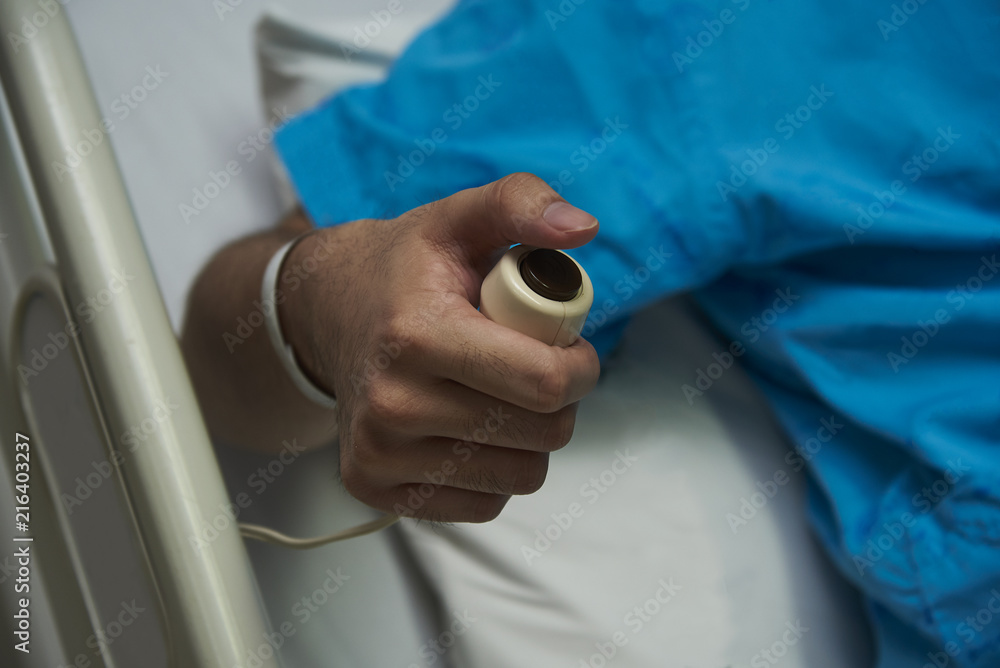 A patient pressing a button calling for nurse A patient pressing a button calling for nurse