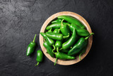 Green jalapeno hot pepper in wooden plate closeup. Food photography