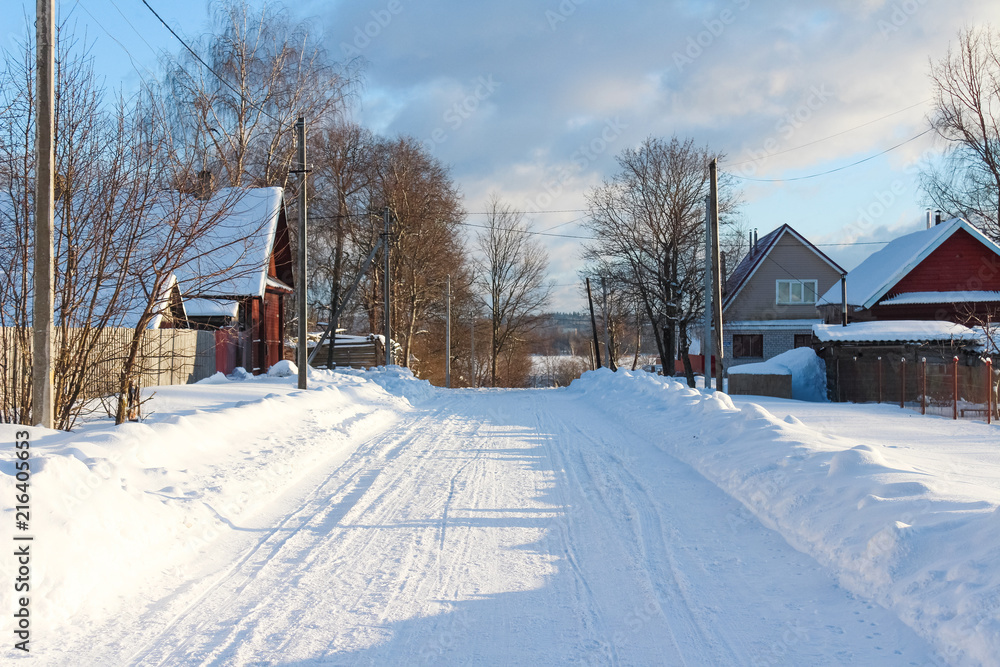 Winter country landscape. Winter road with wooden houses in Russia