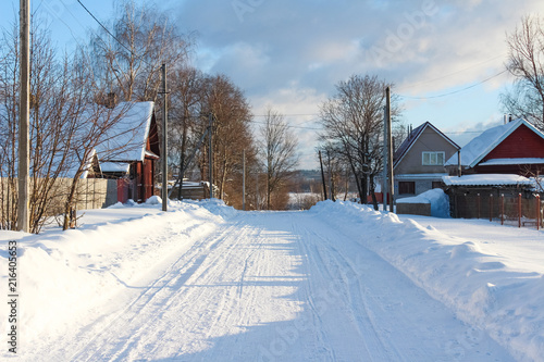 Winter country landscape. Winter road with wooden houses in Russia
