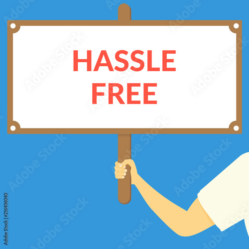 HASSLE FREE. Hand holding wooden sign