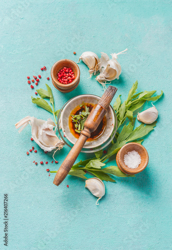 Slika na platnu Various seasoning, herbs and spices with marinate bowl and rub brush on light blue background