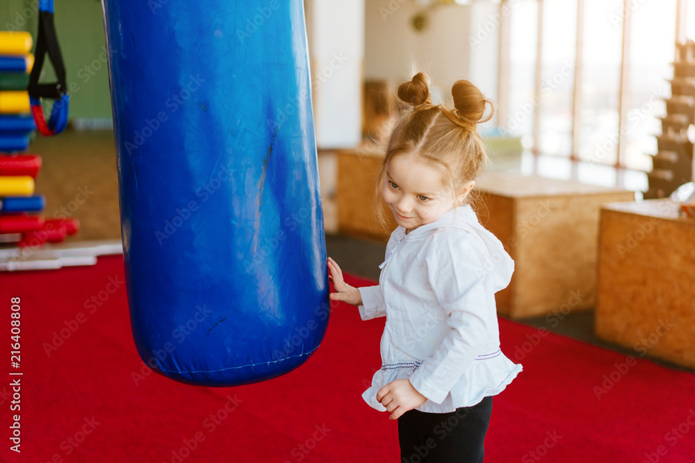 Little girl with a punching bag
