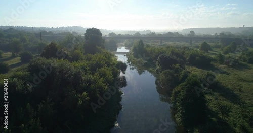 Morning fog on the river, fly over the water, the bridge on which the train rides photo