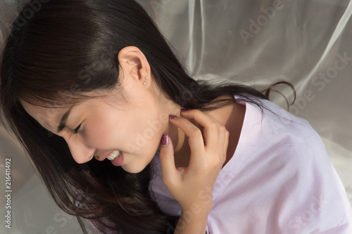 itching woman scratching her neck skin; portrait of asian woman suffering from rash, skin infection, skin allergy, bacteria or ringworm or fungus infection; 20s young adult asian woman model