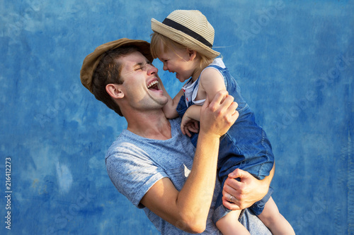 Father and doughter hugging on a blue background. photo