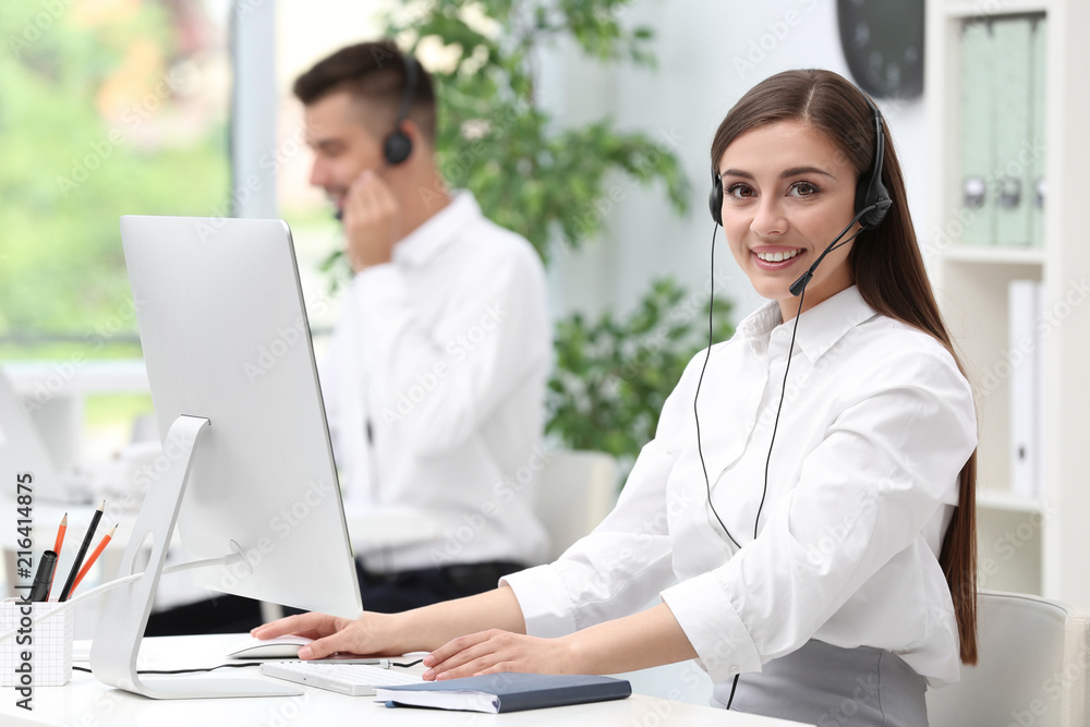 Female receptionist with headset at desk in office Female receptionist with headset at desk in office