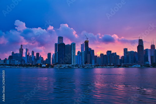 Colorful sunset reflecting onto clouds  Lake Michigan  and Chicago skyline during summer recreation season.