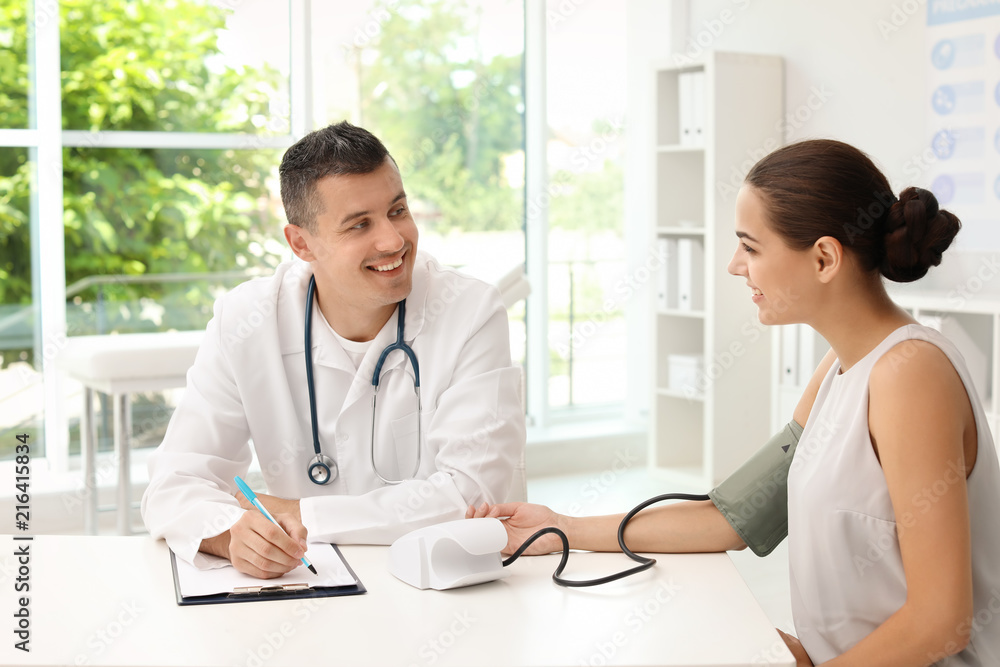Doctor checking patient's blood pressure in hospital Doctor checking patient's blood pressure in hospital