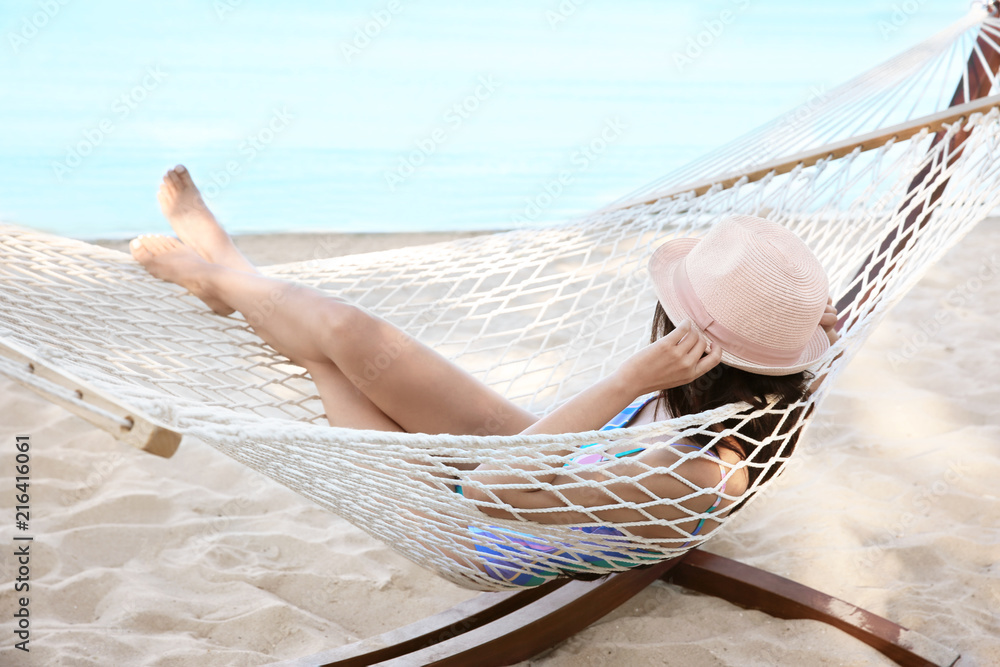 Young woman resting in hammock at seaside. Summer vacation