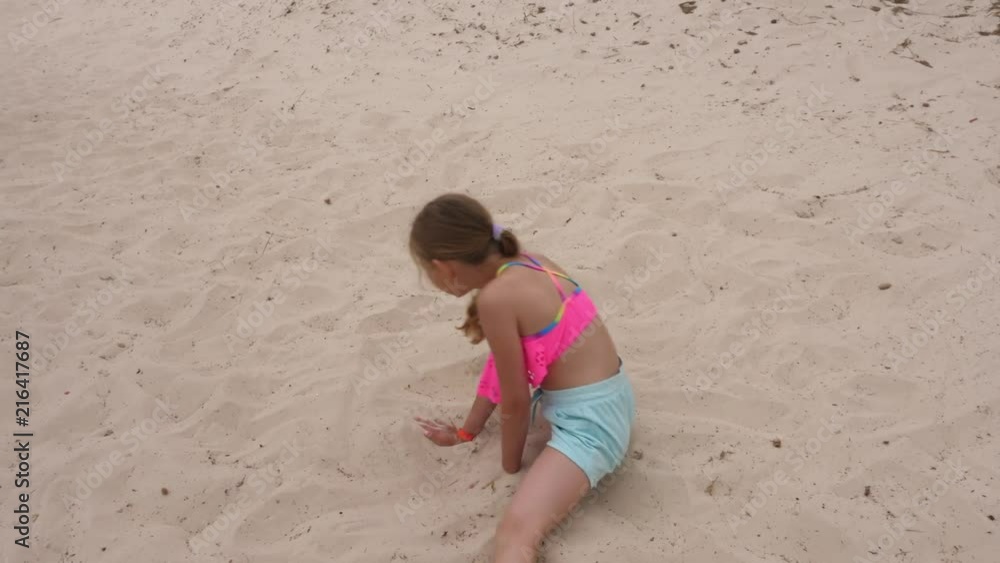 Adorable young girl breakdancing on sandy beach Adorable young girl breakdancing on sandy beach