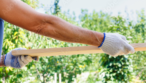 Caucasian man holding planks in the hands of bright sky