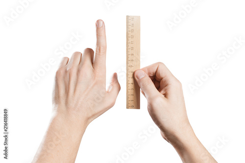 Hands testing a wooden ruler, isolated on white background photo