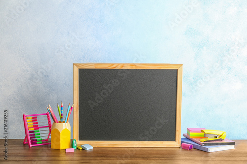 Small chalkboard and different school stationery on table