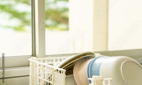 Clean dishes stack in the dish rack of kitchen sink counter