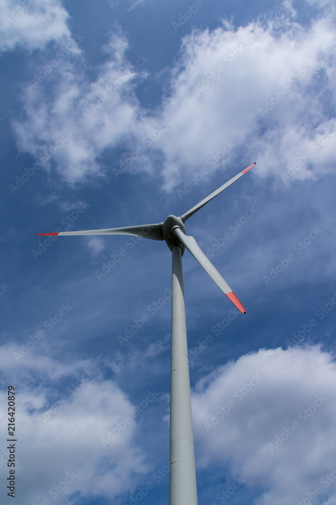 Windkraftanlage mit Flügel Teilansicht vor blauen Himmel mit Wolken