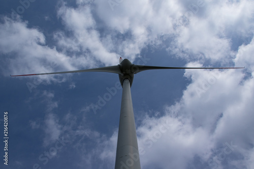 Windenergieanlage mit Blick von unten auf Propeller Himmel und Wolken
