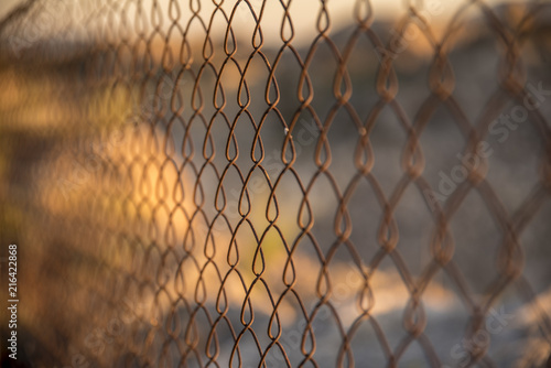 Reja difusa oxidada y abandonada en el campo limitando una parcela En un atardecer asombroso con una puesta de sol apoteosica
