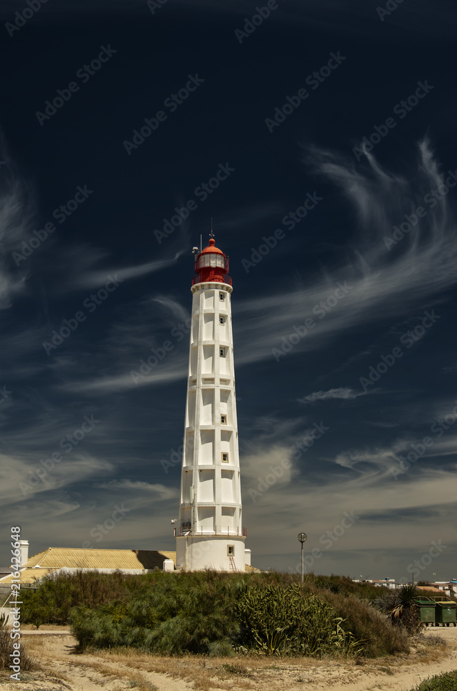 Wysoka latarnia morska, pionowe zdjęcie. Portugalia, wyspa Farol.