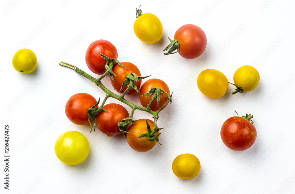 Red and yellow cherry tomatoes on a white background Red and yellow cherry tomatoes on a white background