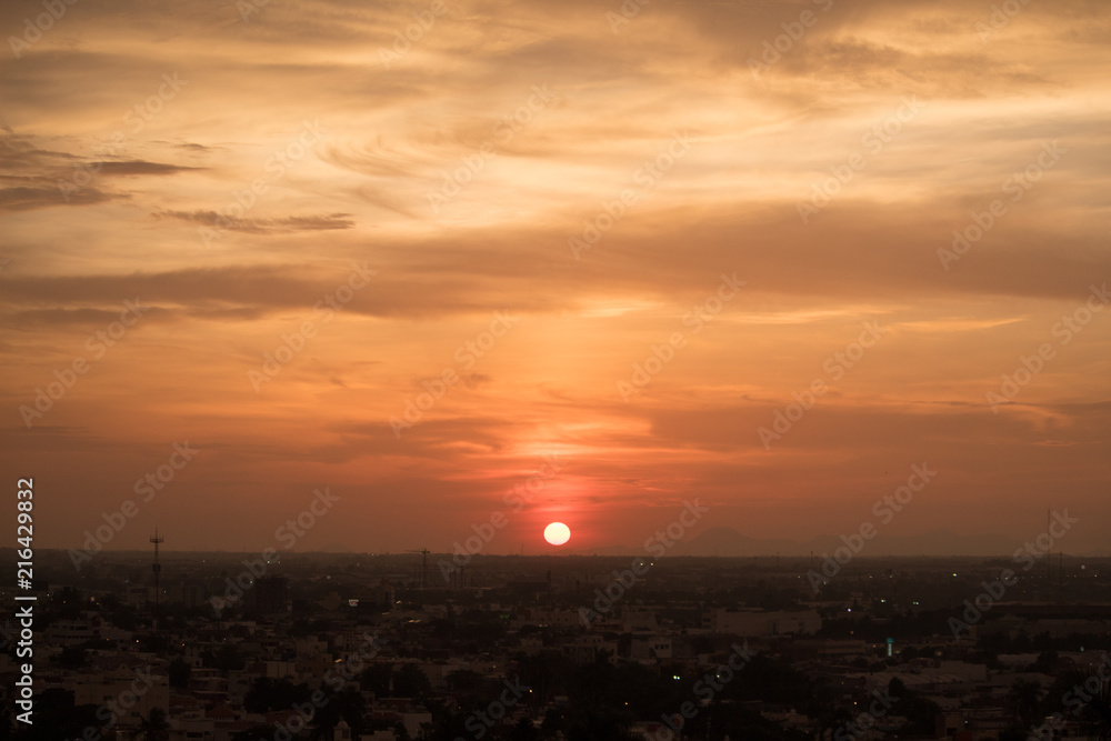 Sol rojo en el horizonte sobre la ciudad 