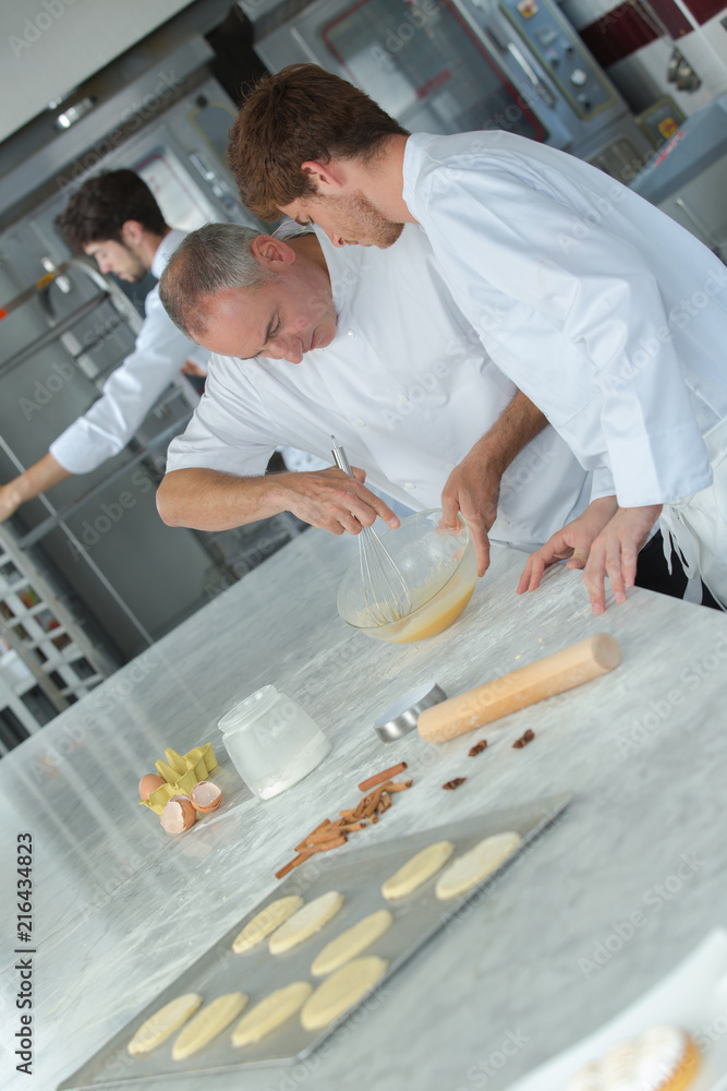 Fototapeta premium apprentices in pastry learning with experienced chef