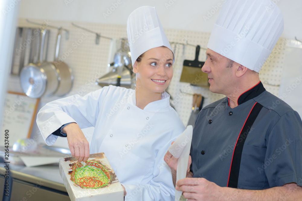 male and female chefs working at kitchen