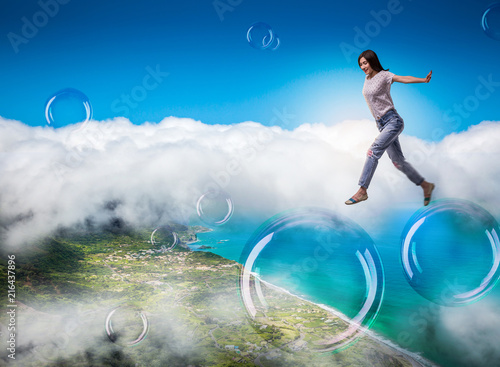 Cute woman jumping in the sky on big soap bubbles © Nomad_Soul