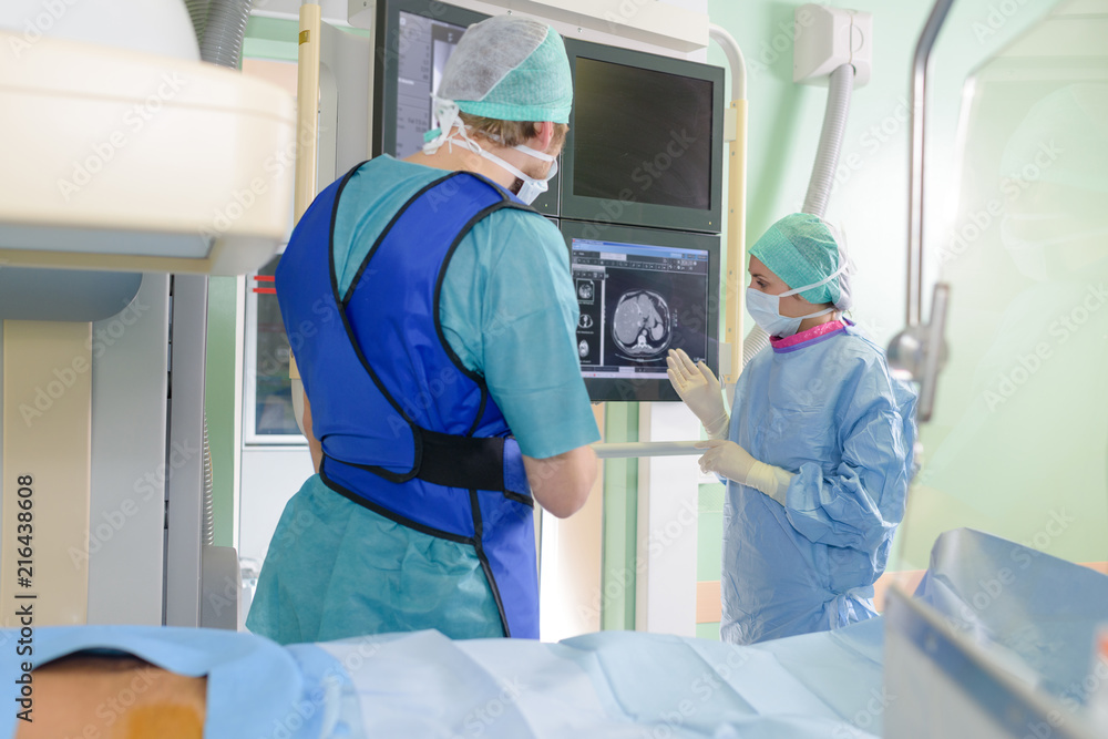 Surgeons consulting image on screen Surgeons consulting image on screen