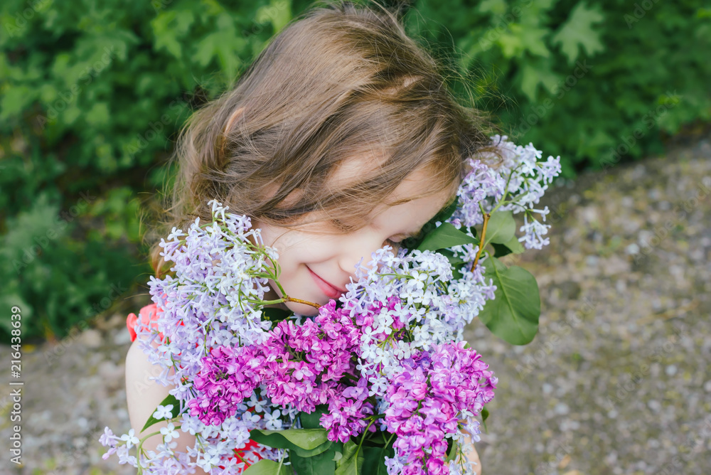 happy girl holding a bouquet of lilac. happy mother's Day! girl congratulates her mother, gives a bouquet of lilac flowers. happy girl holding a bouquet of lilac. happy mother's Day! girl congratulates her mother, gives a bouquet of lilac flowers.