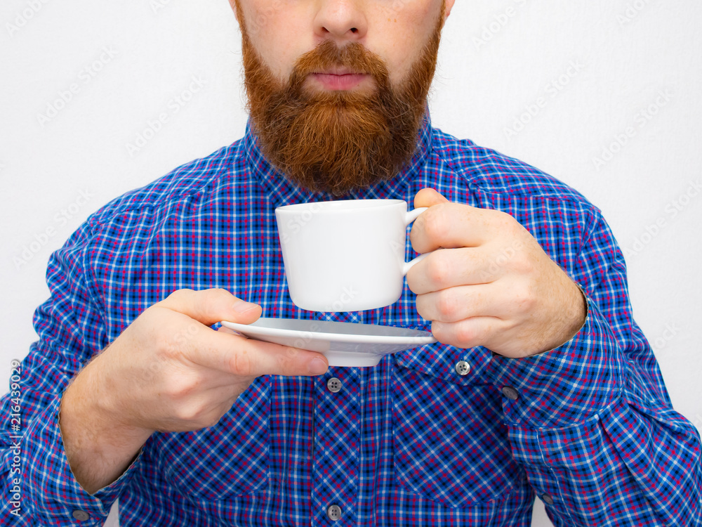 handsome bearded man with stylish hair beard and mustache on serious face in shirt holding white cup or mug with good morning text drinking tea or coffee in studio on grey background handsome bearded man with stylish hair beard and mustache on serious face in shirt holding white cup or mug with good morning text drinking tea or coffee in studio on grey background