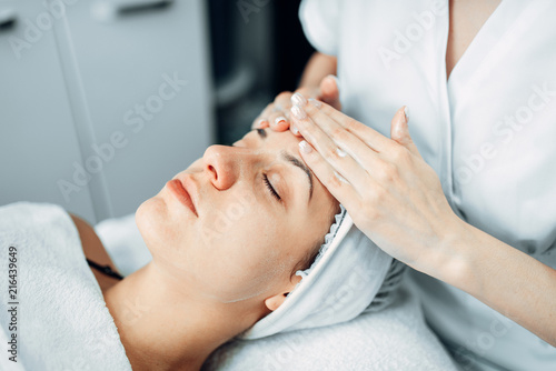 Face massage to female patient, cosmetology clinic