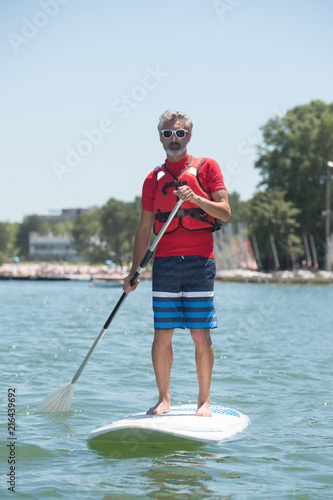 man enjoying a ride on the lake with paddleboard