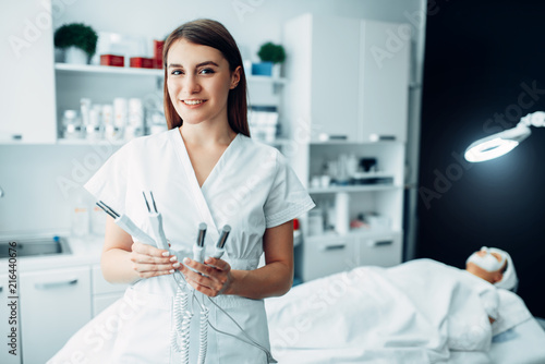 Fotografie Doctor poses with equipment, cosmetology cabinet