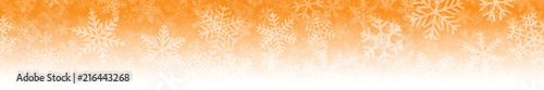 Christmas horizontal seamless banner of many layers of snowflakes of different shapes, sizes and transparency. On gradient background from orange to white.