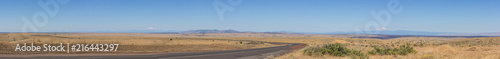 Panorama of central Oregon plains with road 101 and the Cascade mountain range in the horizon.