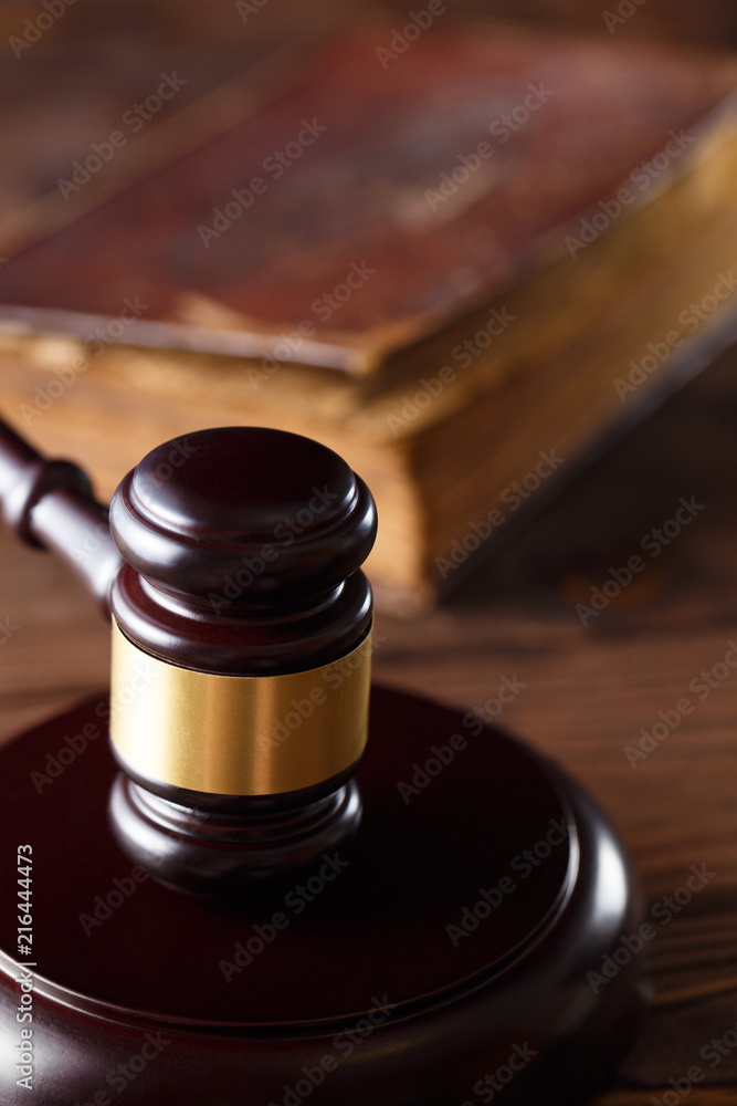 Wooden hammer and ancient book on the wooden table Wooden hammer and ancient book on the wooden table